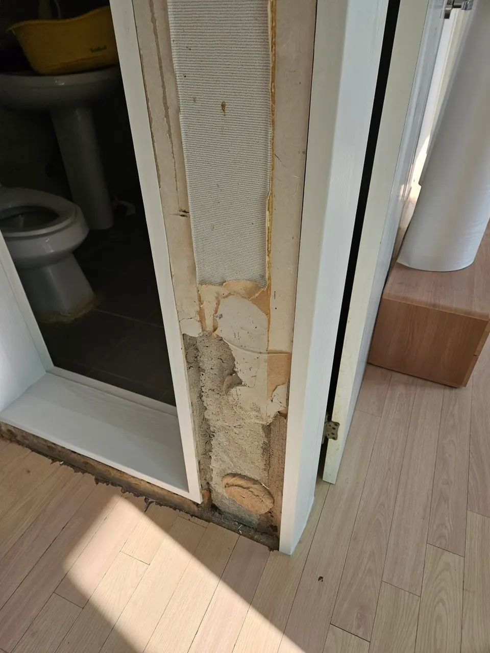 반려견이 물어뜯어 마감이 벗겨진 화장실 문틀 하부