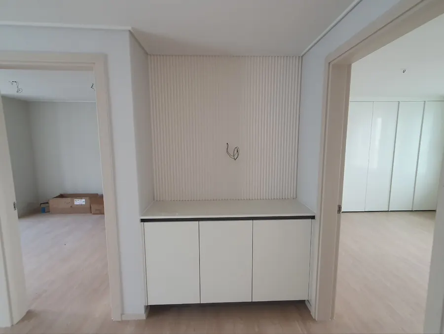 복도 쪽 수납장과 세로 루버 벽 마감