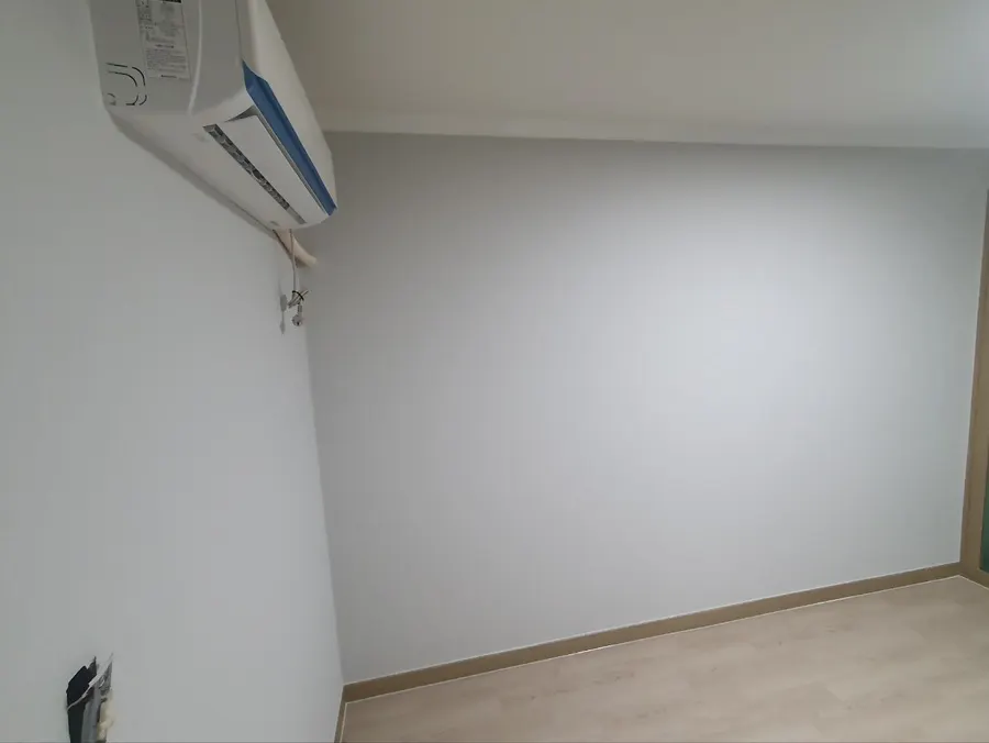 도배를 마친 에어컨 있는 방 벽면
