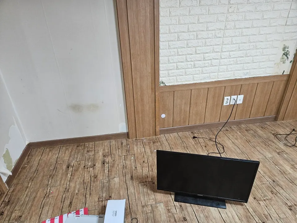 같은 벽 모서리에 짙은 색 걸레받이를 새로 시공한 모습