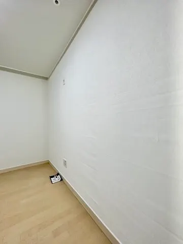 화이트 실크벽지로 도배를 마친 방 모서리