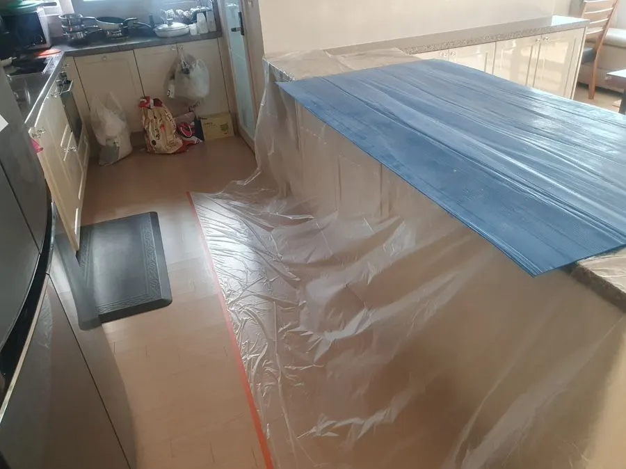 천장 작업 전 주방 가구와 바닥을 비닐로 보양한 모습