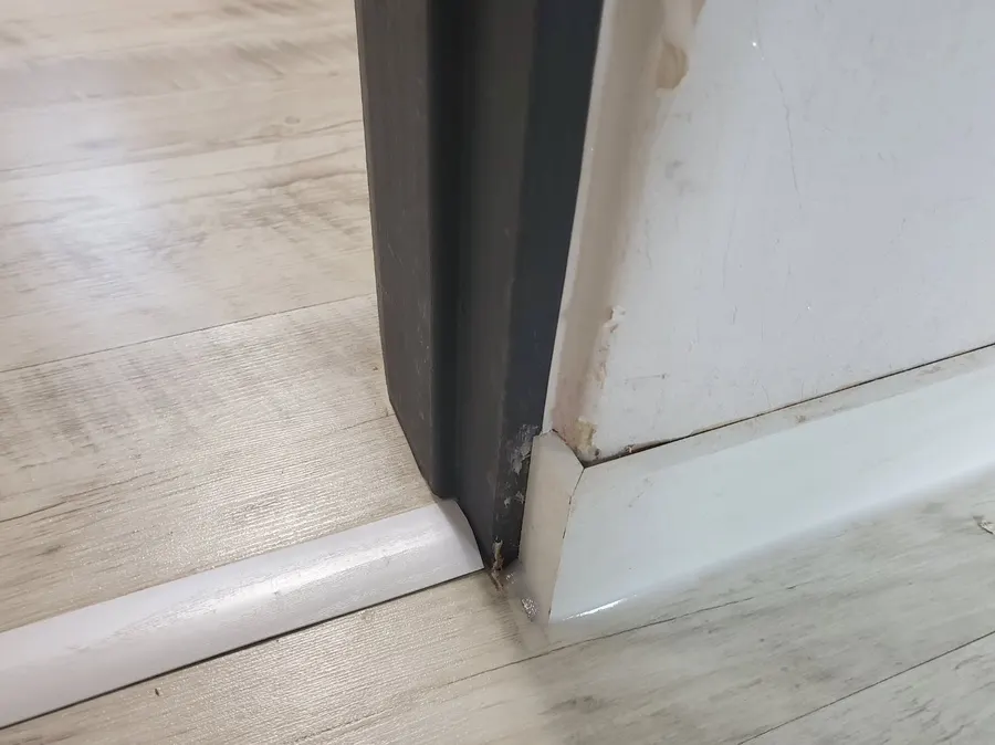문틀 옆까지 이어 붙인 새 걸레받이 근접 모습