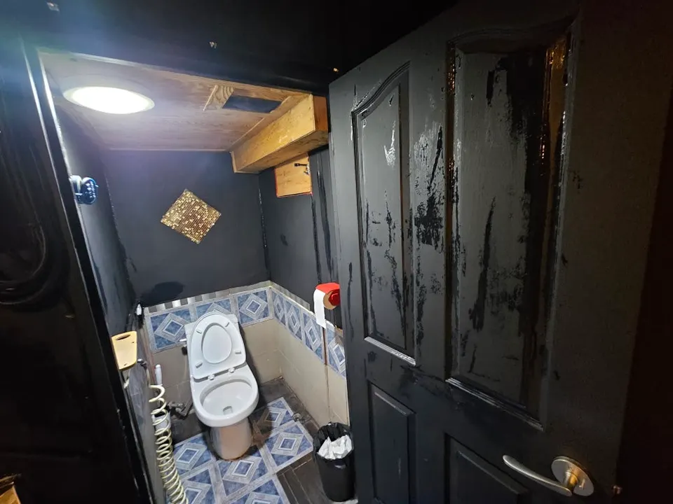 문과 벽을 검은색으로 도장한 PC방 화장실