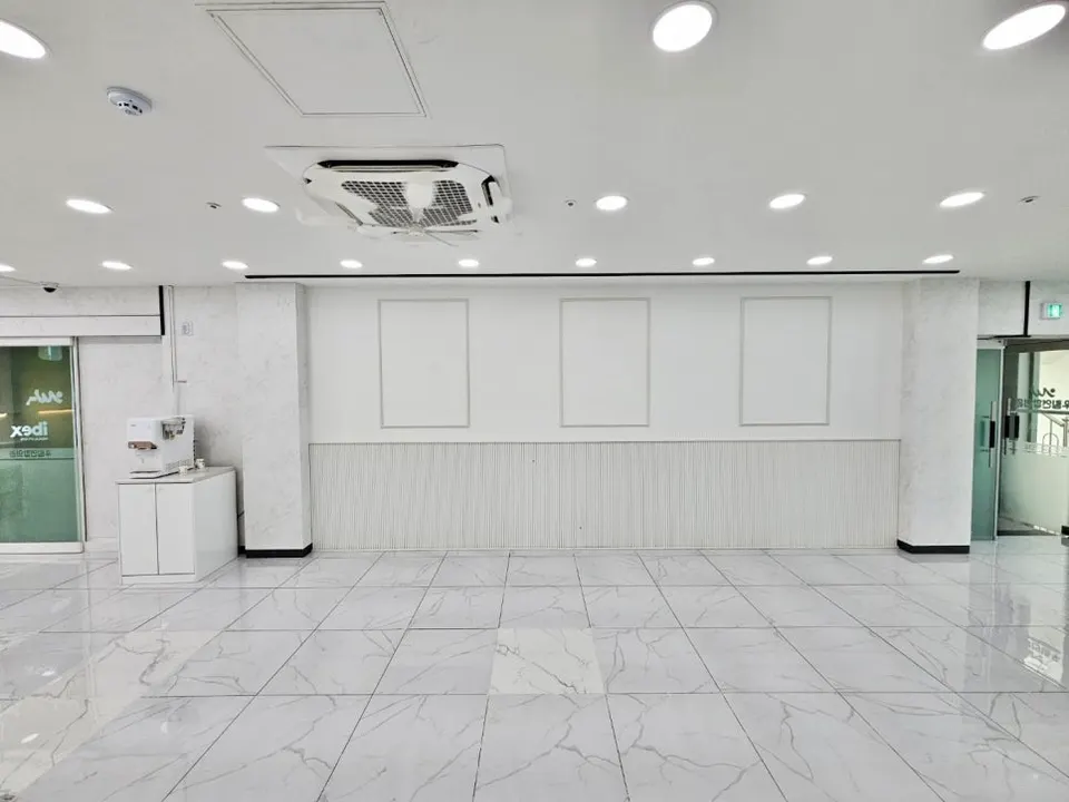 대리석 무늬 템바보드 하부 마감과 게시용 네모 틀을 짠 의원 벽면