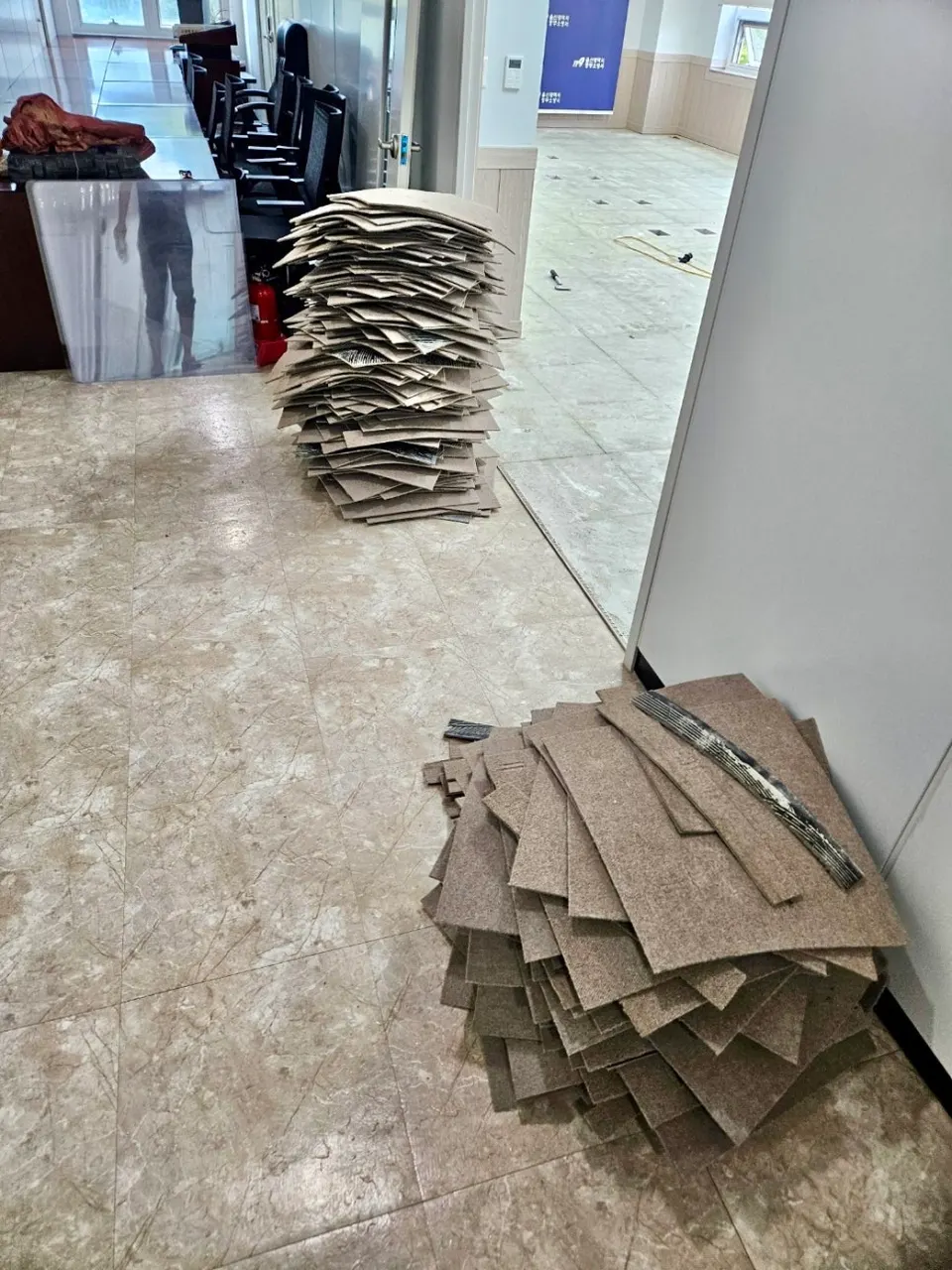 걷어낸 폐 데코타일을 회의실 한쪽에 쌓아 둔 모습