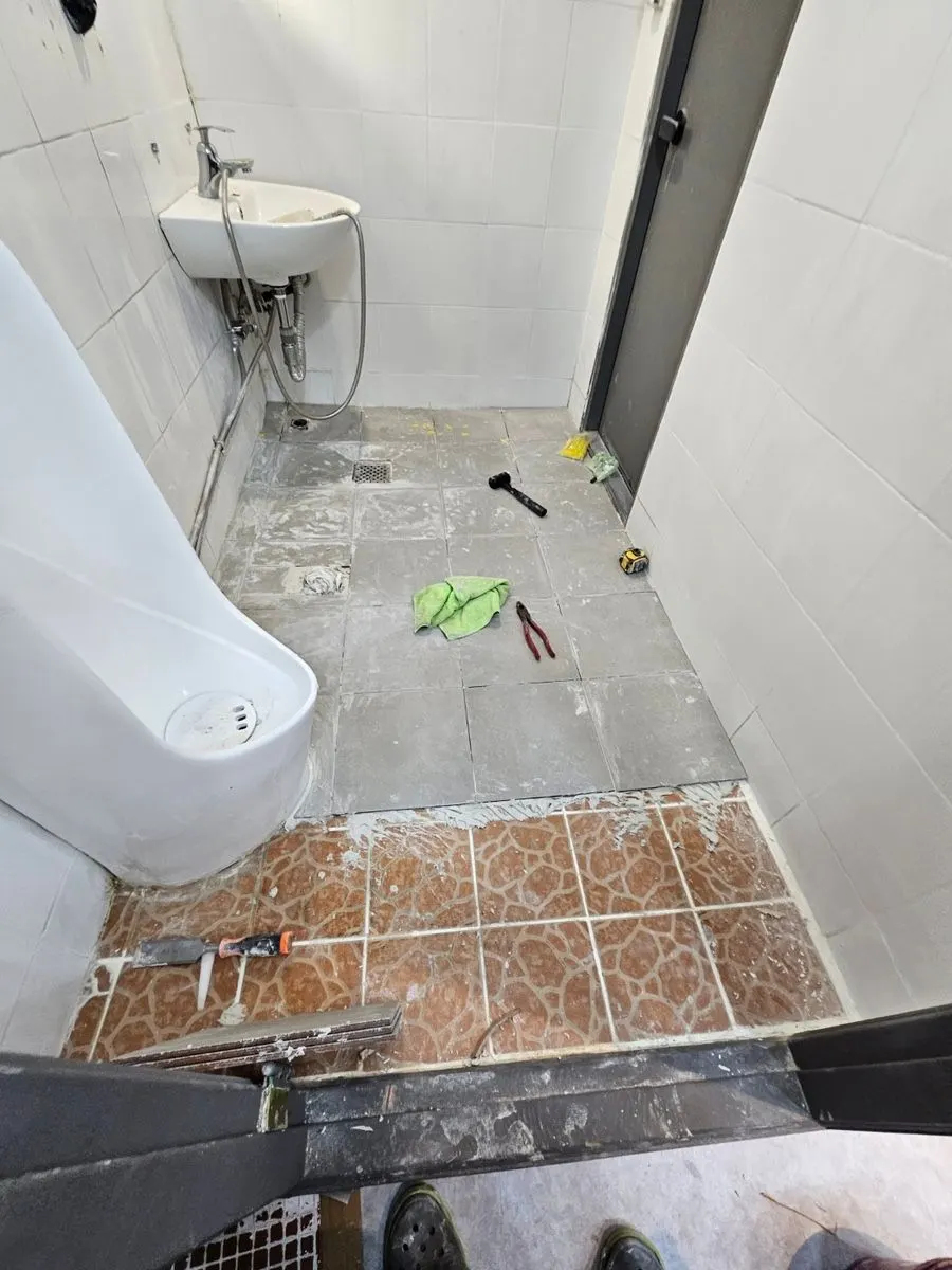 갈색 바닥 타일이 깔린 학원 화장실 시공 전 모습