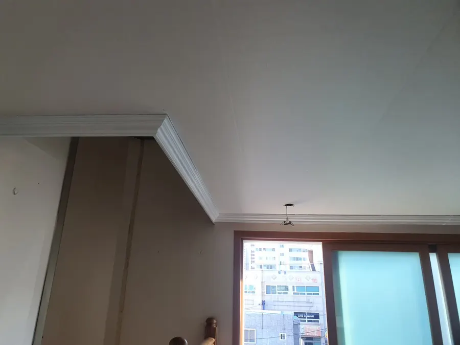 흰색으로 칠한 천장 몰딩과 벽 모서리