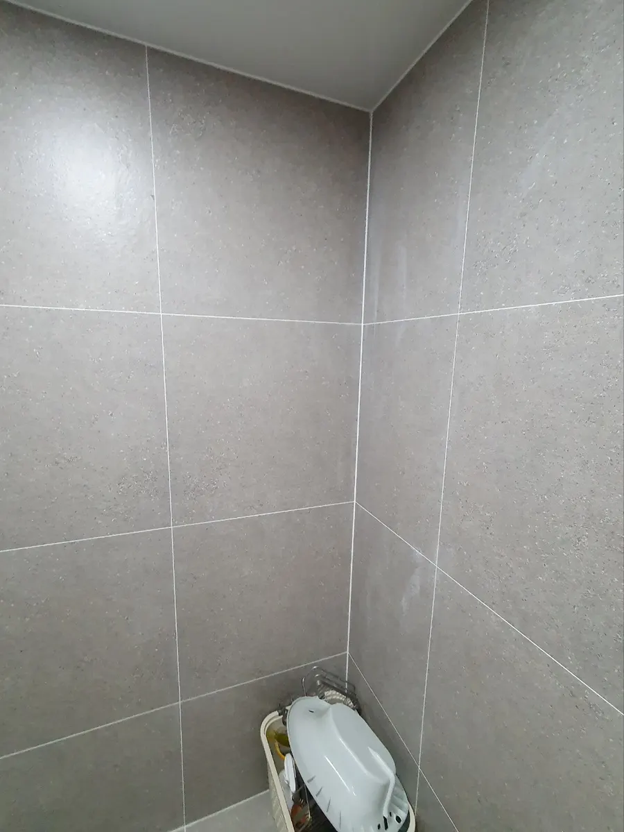 새 타일로 마감한 욕실 벽 모서리