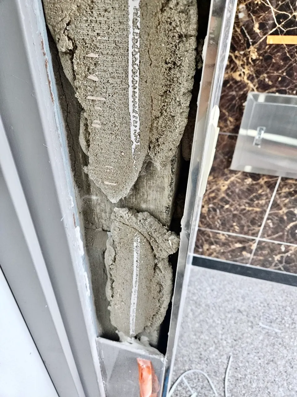들뜬 타일을 떼어 낸 벽면과 기존 접착제 자국