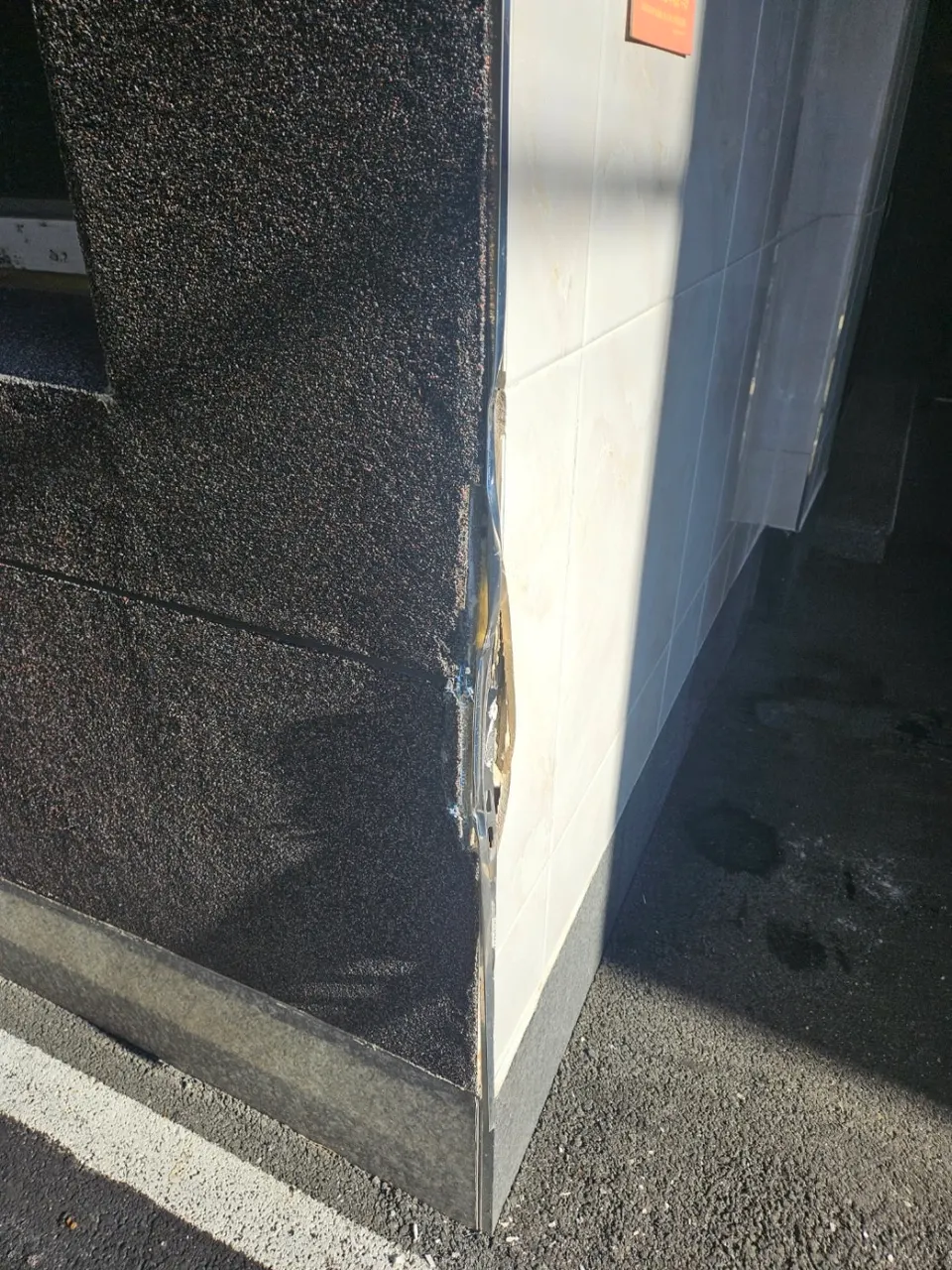 차량 충돌로 깨진 원룸 건물 주차장 모서리 외벽 타일