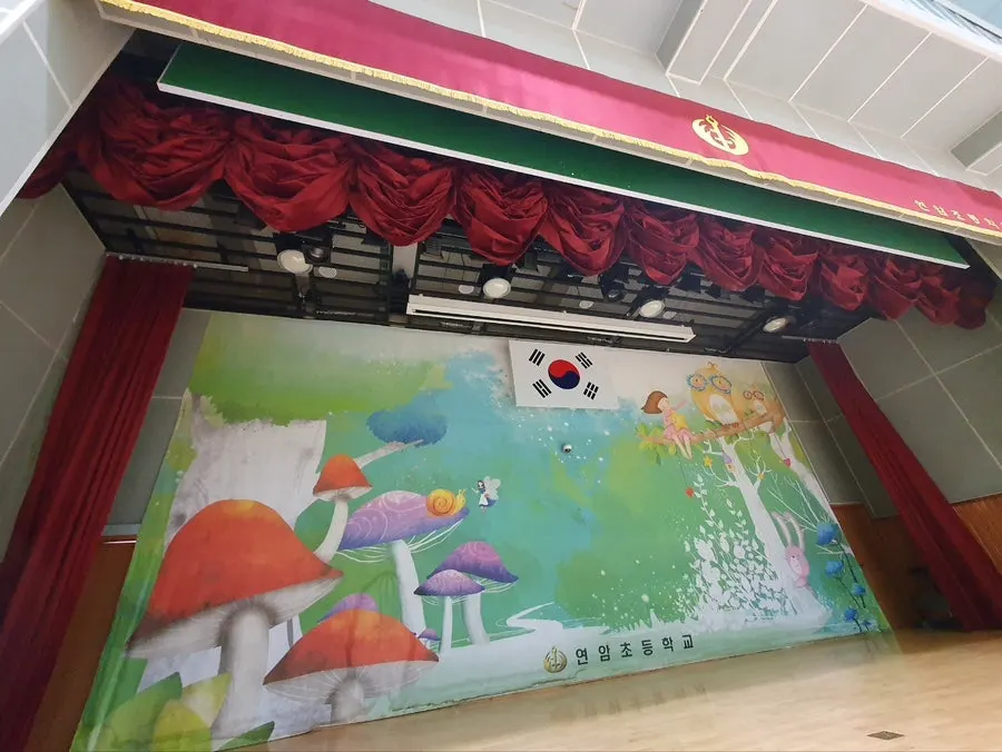 교체 전 붉은색과 녹색 무대커튼이 달린 강당 무대